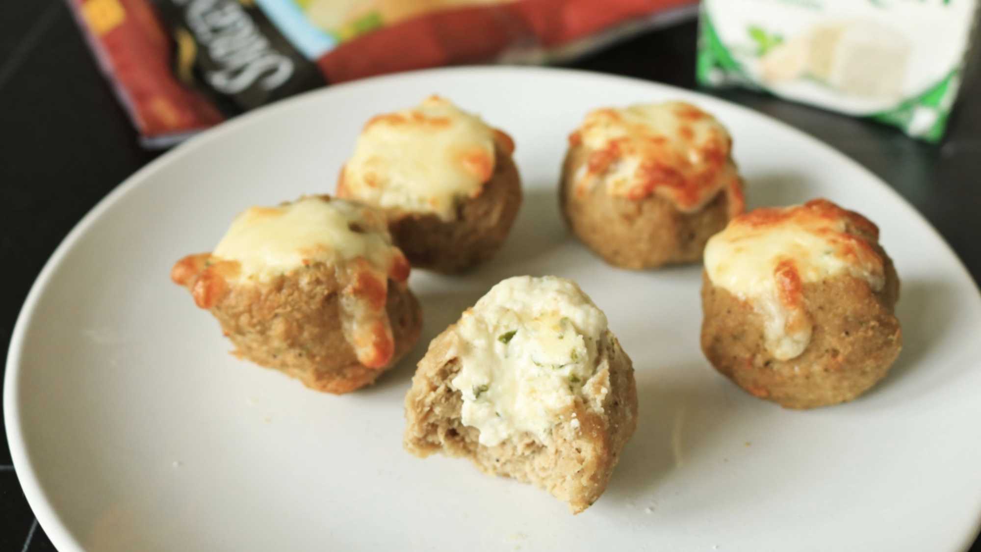 A plate of meatball shots filled with soft cheese.