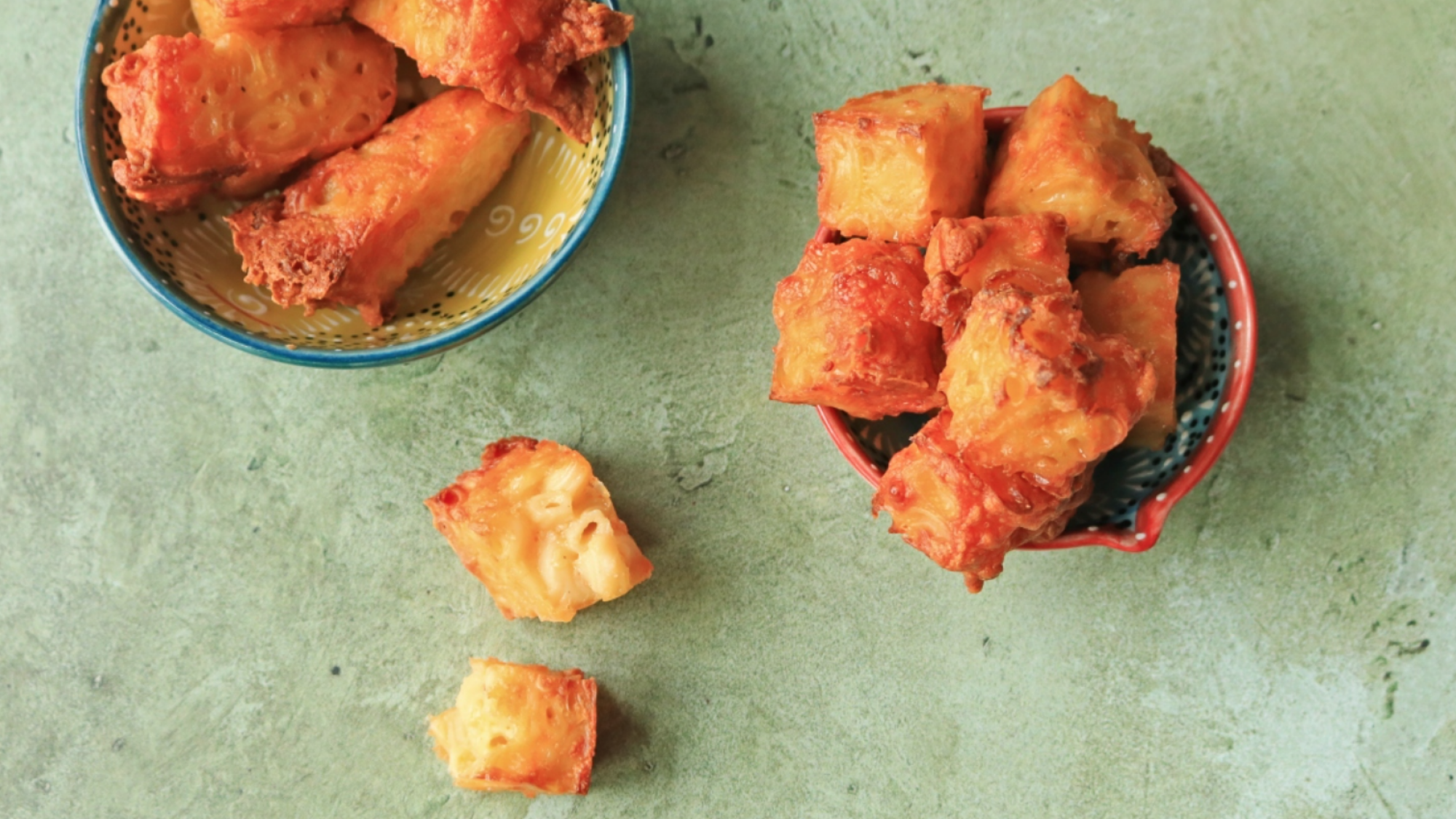 Mac and cheese bites in bowls on a table.